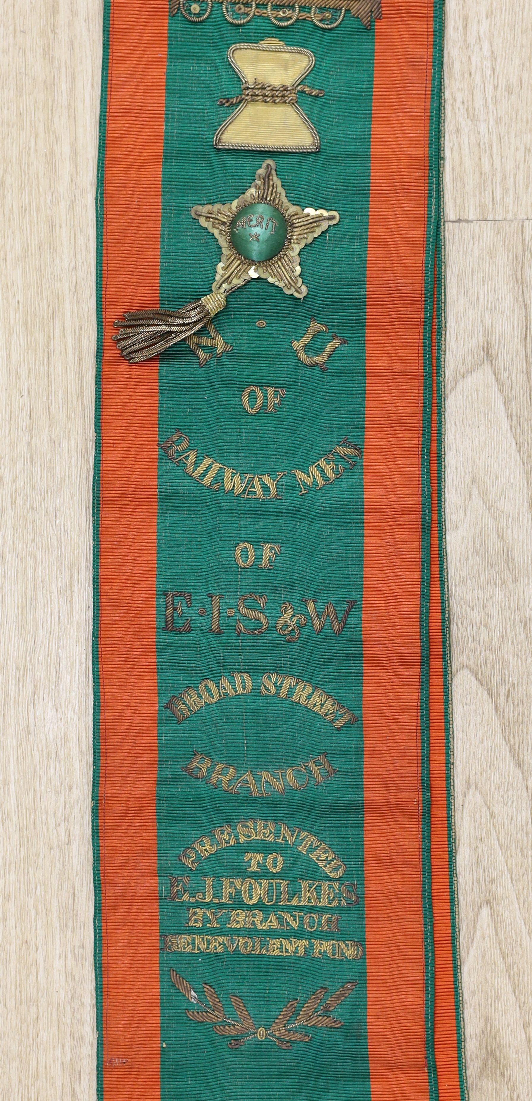 Railway Interest - A metal thread embroidered silk sash inscribed ‘Railway Men of E I S & W, Broad Street Branch - presented to E.J. Foulkes by branch benevolent fund’ - approx 190cm long